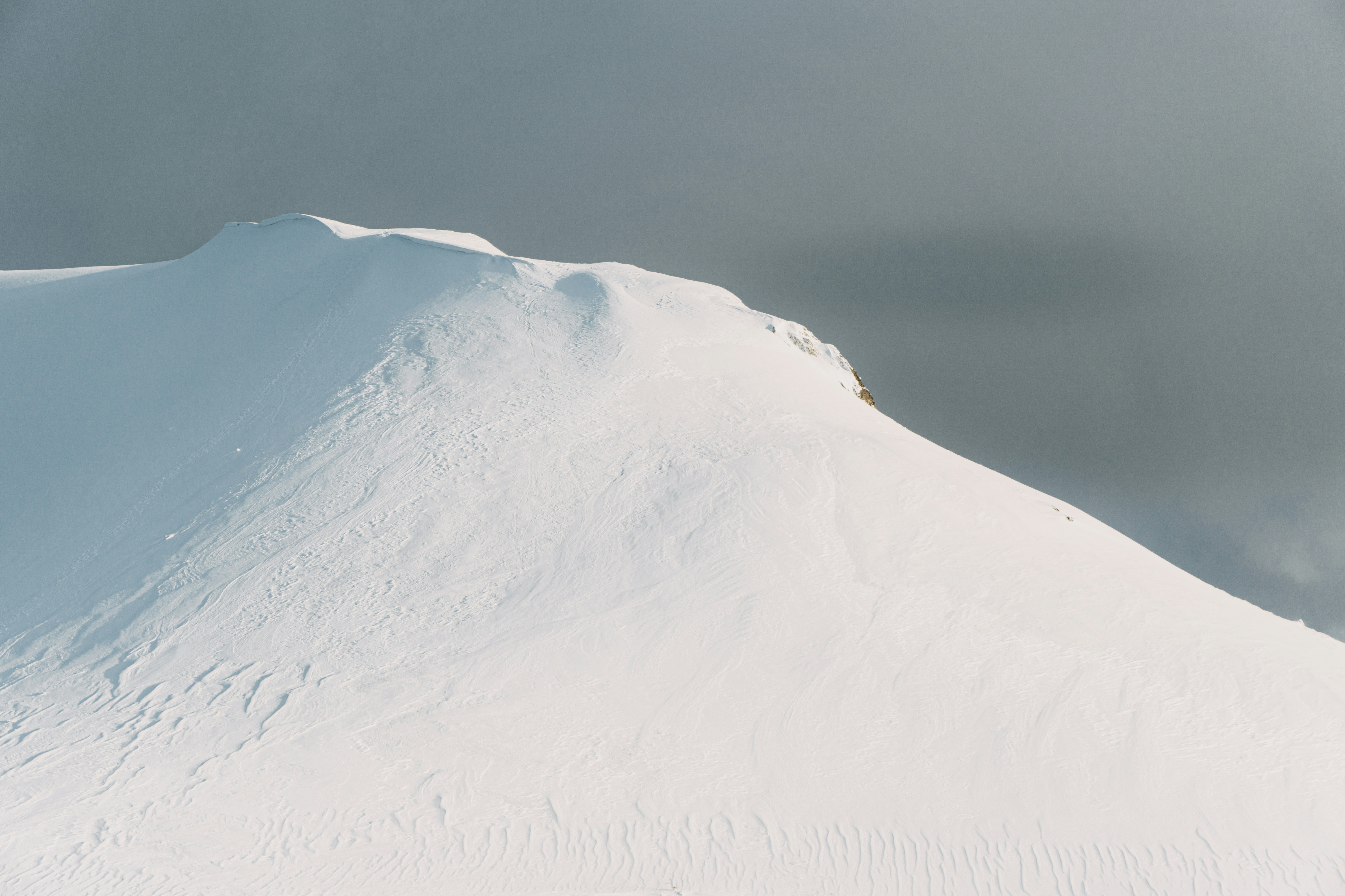 snow covered mountain under gray sky